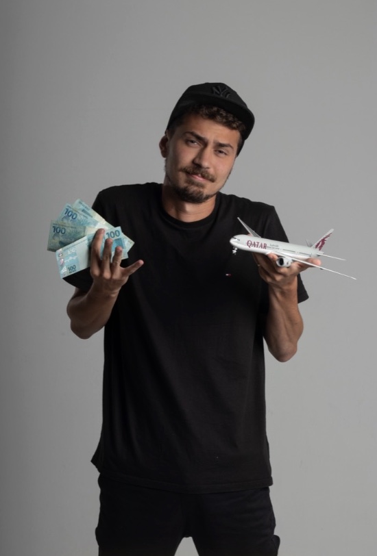 Matheus Tiburtino segurando dinheiro e um avião da Qatar Airways